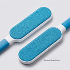 Double-sided lint brush with two teal bristle pads on a white-and-blue handle.