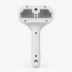 Handheld pet grooming brush with white handle and dual rows of metal bristles