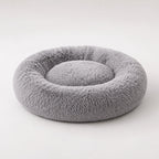 Gray donut pet bed with plush outer bolster and inner nest