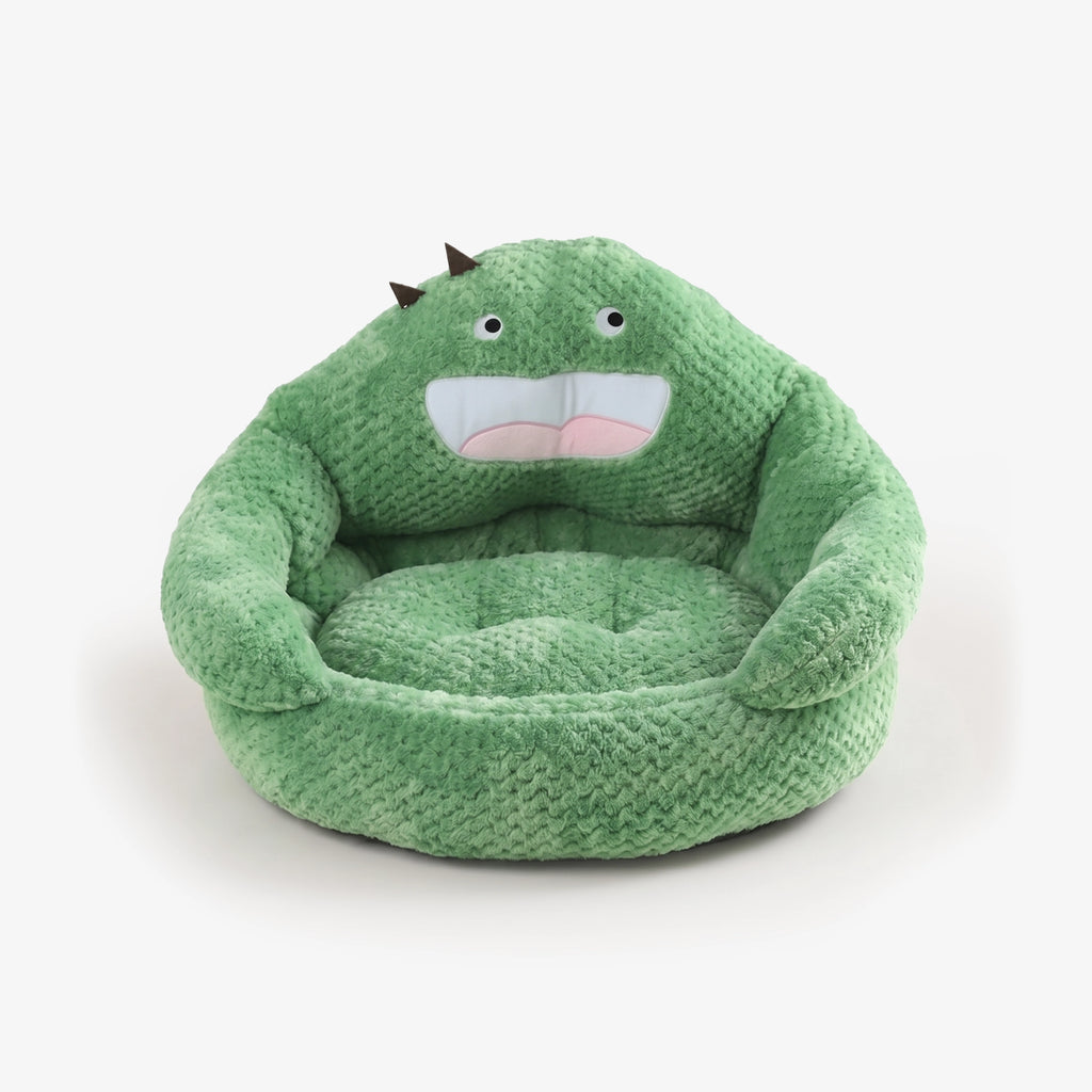 Green plush pet bed with stitched cartoon face and raised cozy rim