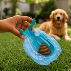 Teal handle releasing a blue poop bag near a golden retriever on grass