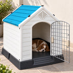 Outdoor pet house with blue roof and open door, dog resting on floor