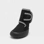 A single black ankle boot with gray trim and a hook-and-loop strap closure, shown from a three-quarters angle on a light gray background.