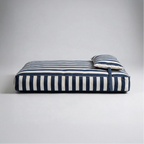 Navy-and-white striped pet bed with rolled edge and top bolster cushion