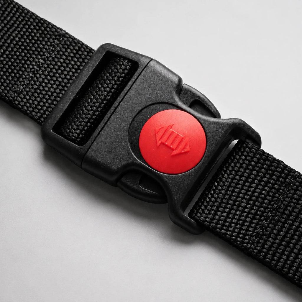 Close-up of belt buckle featuring a red circular release button